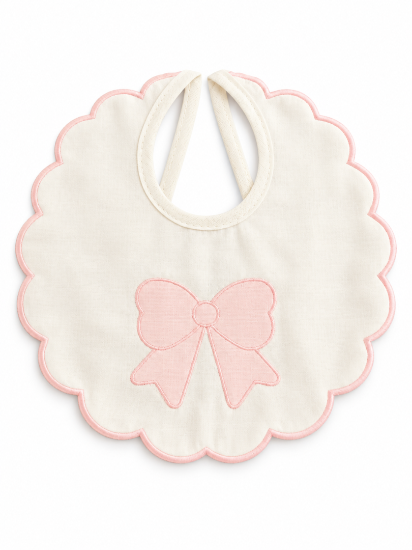 Bavetta neonato Ornella in cotone color panna con grande fiocco rosa ricamato e bordo smerlato rosa